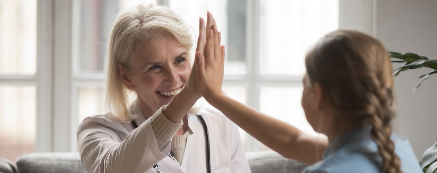 Doctor high-fiving young girl